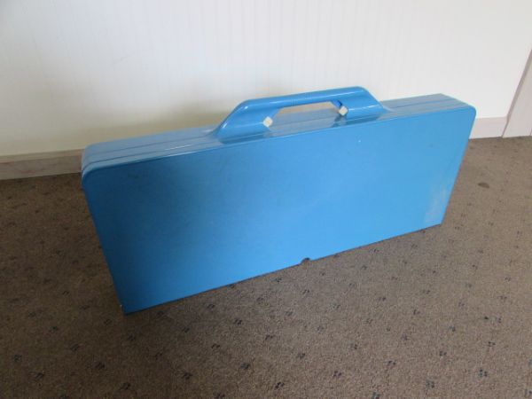 BLUE FOLDING CAMP TABLE WITH ATTACHED BENCHES & A BLUE THERMOS.