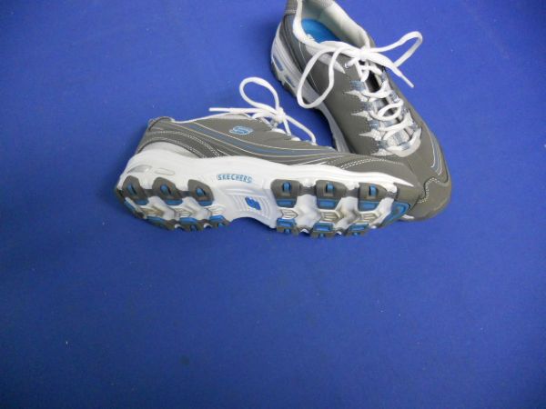 A COMFORTABLE PAIR OF SKECHERS TENNIS SHOES