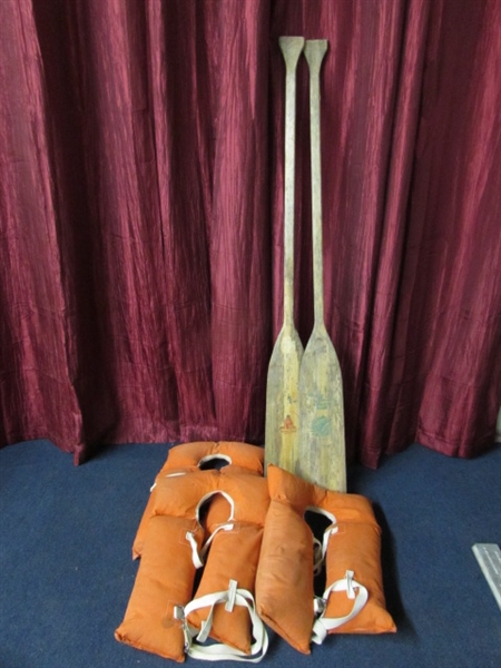 TWO VINTAGE INDIAN HEAD WOODEN OARS & THREE ORANGE CANVAS LIFE VESTS