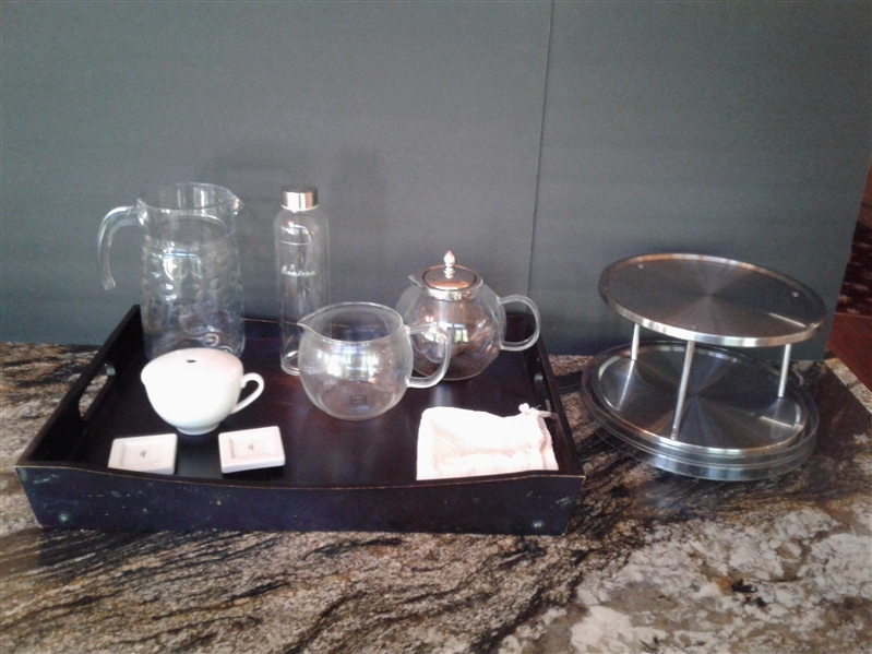Glass tea pots, pitcher. wood serving tray and metal server on lazy susan