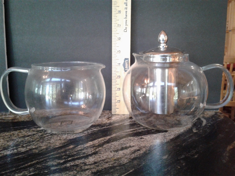 Glass tea pots, pitcher. wood serving tray and metal server on lazy susan