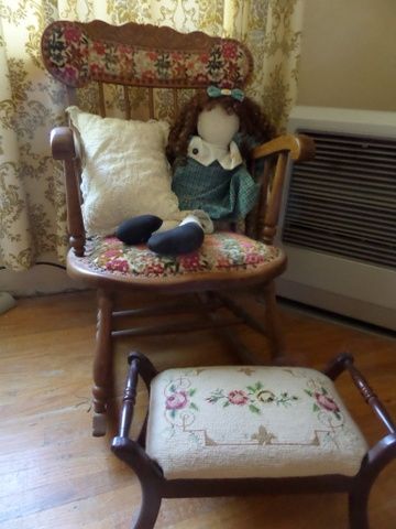 ANTIQUE OAK ROCKER CHAIR WITH UPHOLSTERED SEAT AND BACK. NEEDLE POINT FOOT STOOL,  LARGE RAG DOLL