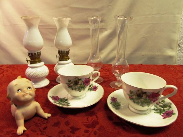 VINTAGE & UNIQUE MINIATURE CROWN MILK GLASS HURRICANE LAMPS, CERAMIC KEWPIE, TEA CUPS & SAUCERS & TWO RUFFLE TOP BUD VASES