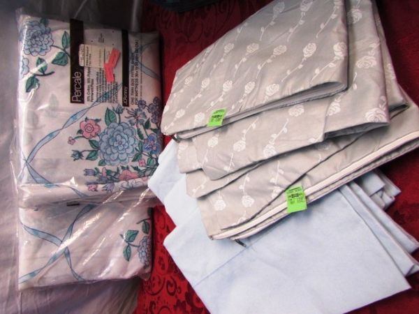 HUGE VARIETY OF NEVER USED SHEETS , 2 MATTRESS PADS & A CASE TO CARRY THEM HOME IN 