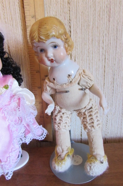 SMALL KEWPIE DOLL & 2 SMALL PORCELAIN DOLLS WITH STANDS