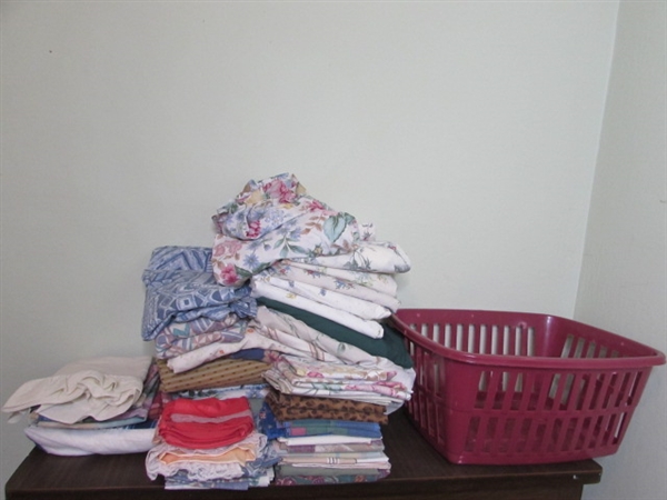 Assorted Sheets and Pillow Cases in Laundry Basket