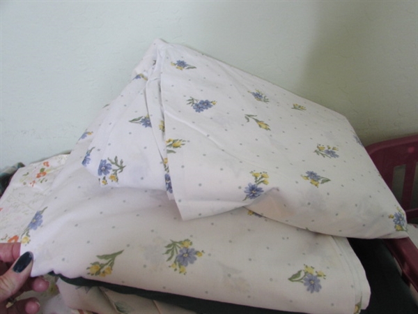 Assorted Sheets and Pillow Cases in Laundry Basket