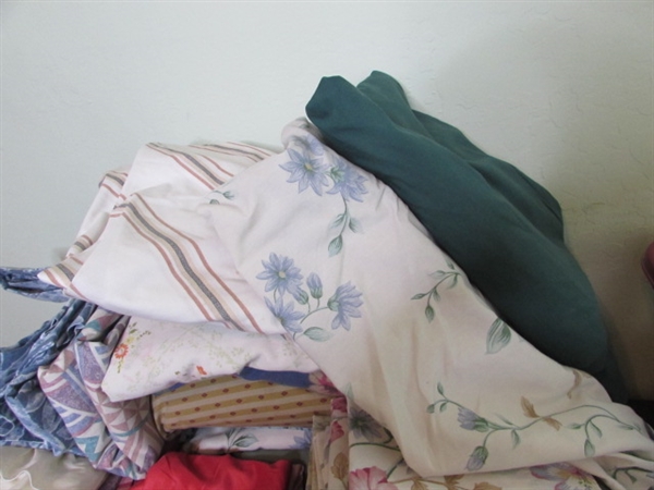 Assorted Sheets and Pillow Cases in Laundry Basket