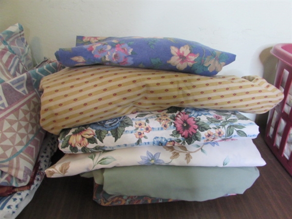 Assorted Sheets and Pillow Cases in Laundry Basket