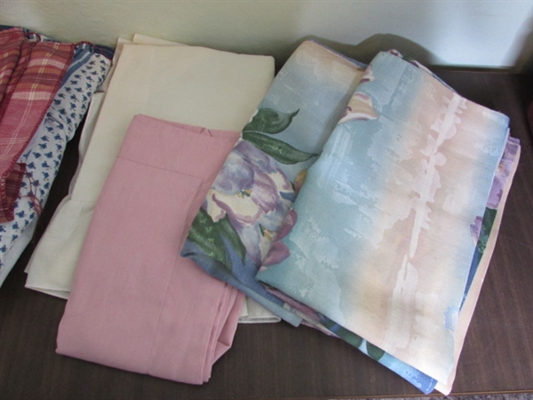 Assorted Sheets and Pillow Cases in Laundry Basket