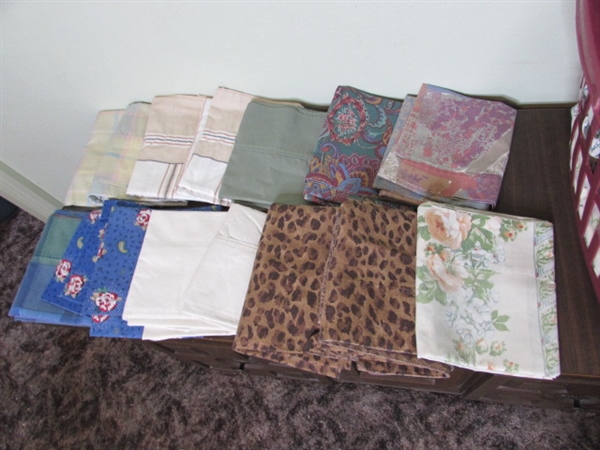 Assorted Sheets and Pillow Cases in Laundry Basket