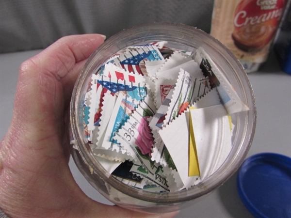 4 CONTAINERS OF POSTAGE STAMPS - MOST LOOK TO BE CANCELLED