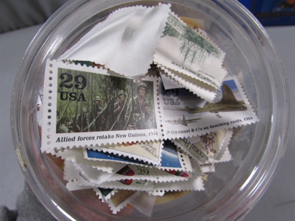 4 CONTAINERS OF POSTAGE STAMPS - MOST LOOK TO BE CANCELLED